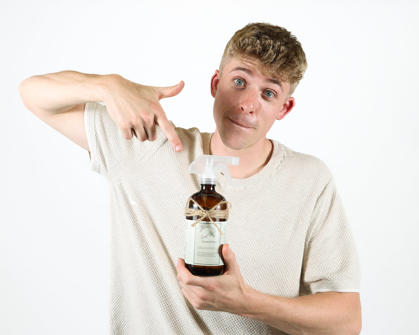 Image showing small business owner promoting product. Pointing at bottle in hand and smiling for professional photoshoot